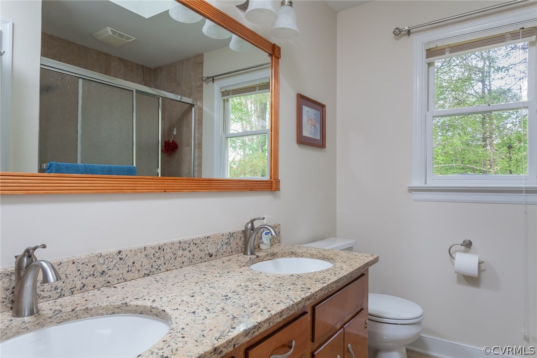 5702 Grove Forest Road Midlothian, VA 23112 - Photo 17 of 30 a bathroom with a granite countertop sink a toilet and a window