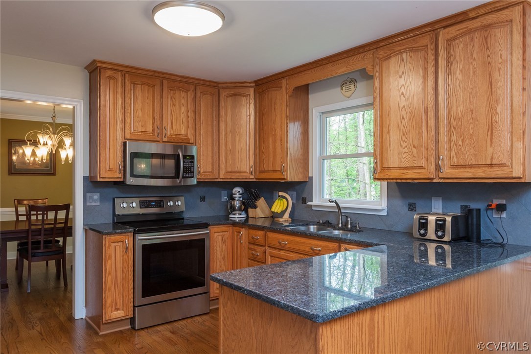 5702 Grove Forest Road Midlothian, VA 23112 - Photo 9 of 30 a kitchen with stainless steel appliances granite countertop a stove a sink dishwasher and a microwave with wooden floor