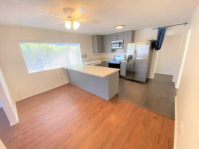 a view of kitchen and living room with wooden floor