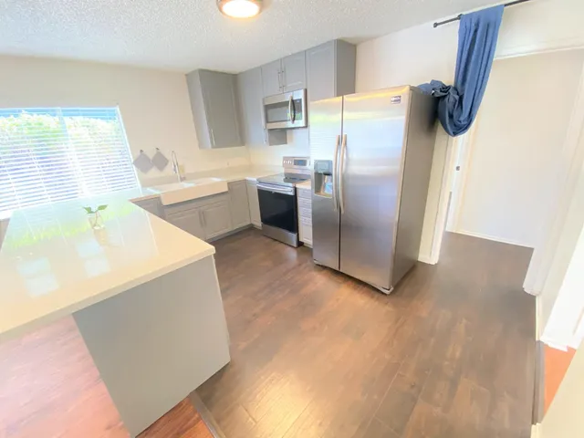 a kitchen with a refrigerator sink and cabinets