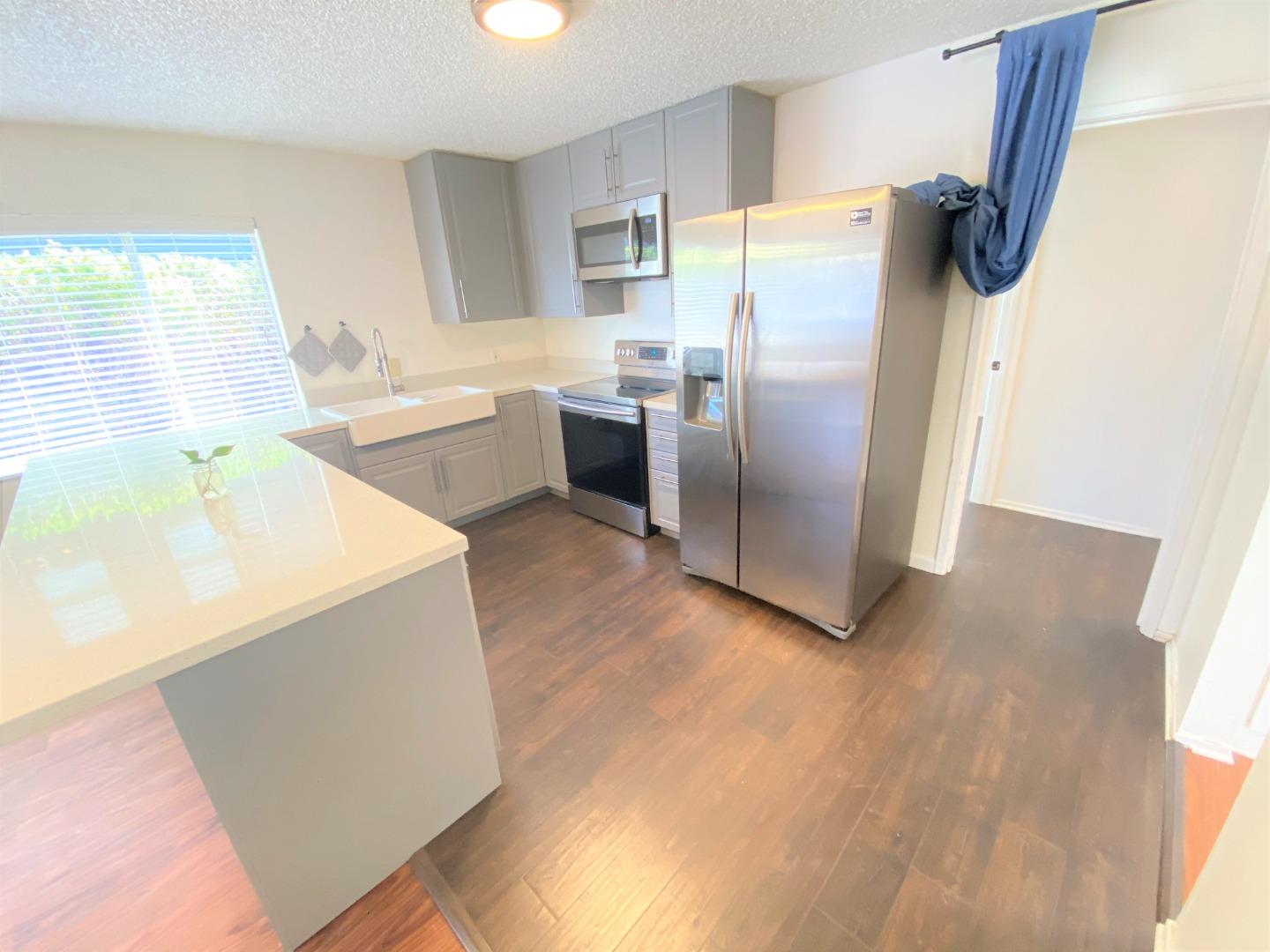 1818 63rd Street Berkeley, CA 94703 - Photo 4 of 15 a kitchen with a refrigerator sink and cabinets