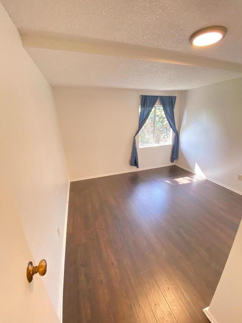 1818 63rd Street Berkeley, CA 94703 - Photo 7 of 15 an empty room with wooden floor and windows