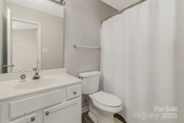 a bathroom with a sink a toilet and a mirror