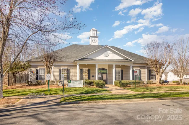 a front view of a house with a big yard and potted plants