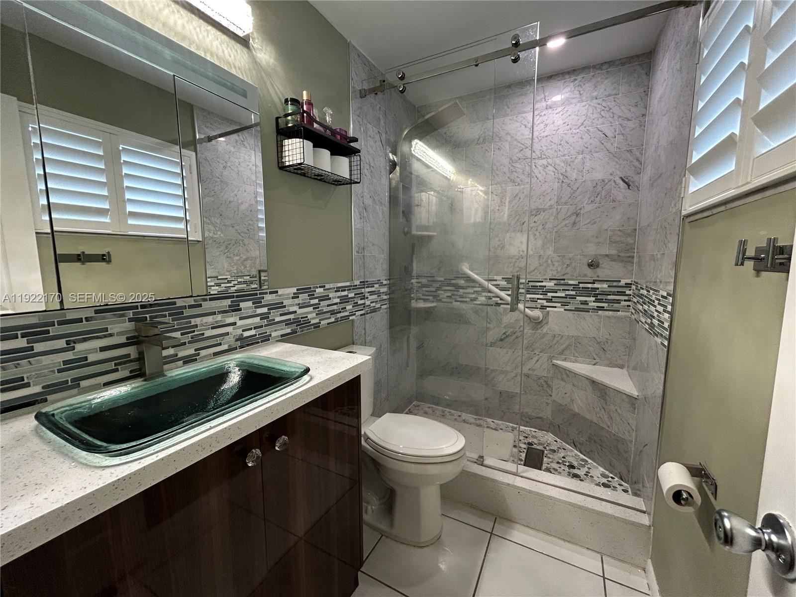 4905 Northwest 49th Road Tamarac, FL 33319 - Photo 14 of 25 a bathroom with a sink a toilet and shower