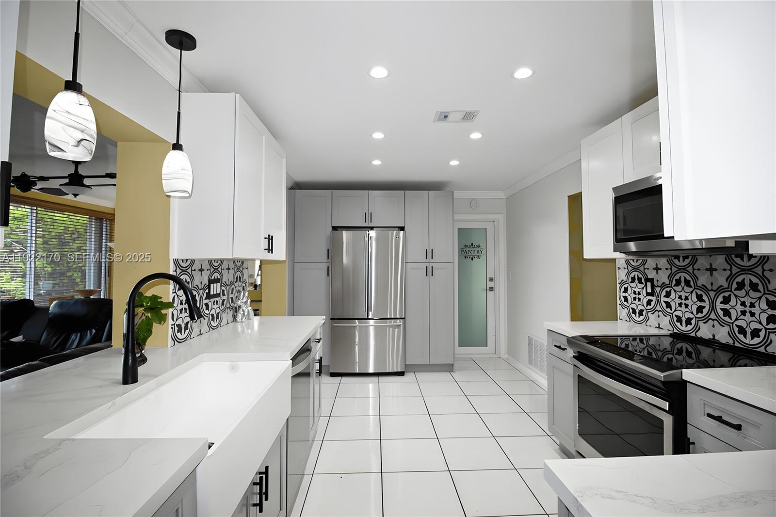 4905 Northwest 49th Road Tamarac, FL 33319 - Photo 5 of 25 a kitchen with stainless steel appliances granite countertop a sink a stove and a refrigerator