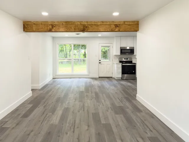 a open kitchen with white cabinets and wooden floor
