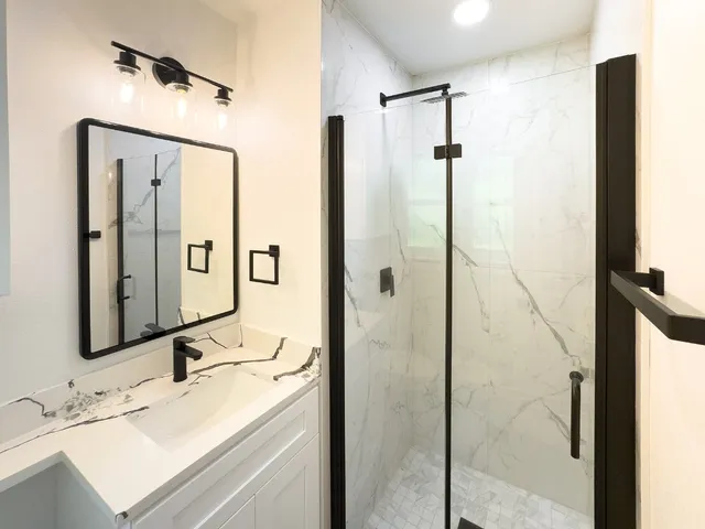 a bathroom with a shower sink and mirror