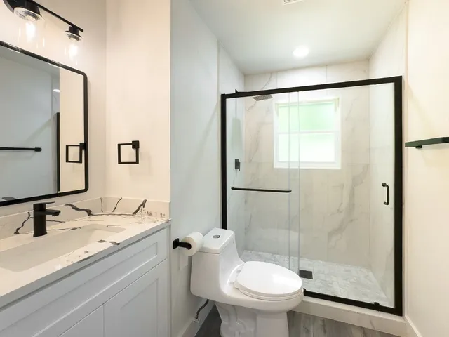 a bathroom with a sink toilet and shower
