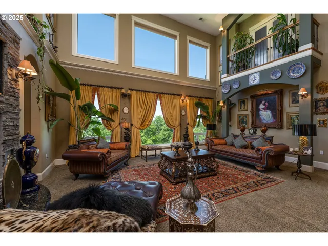 a living room with furniture large windows and wooden floor