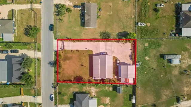 aerial view of a house with a yard and large trees