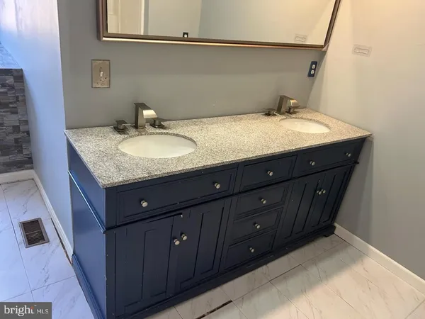 a bathroom with a granite countertop sink and a mirror