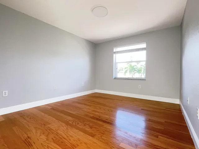 a view of a hallway with closet and wooden floor