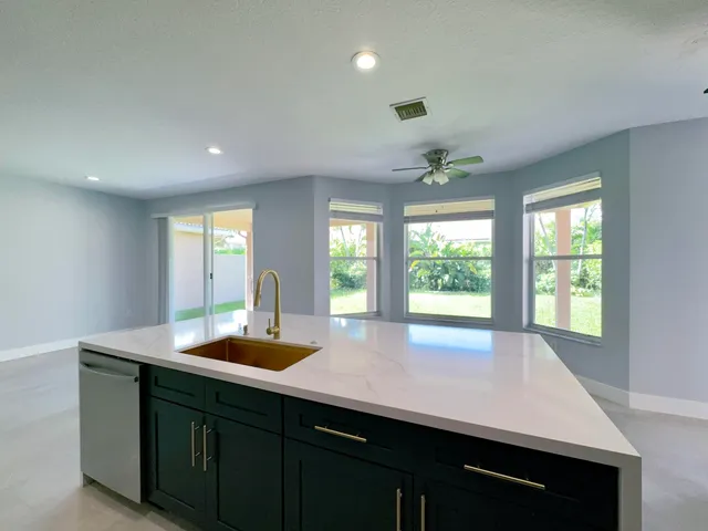 a large kitchen with stainless steel appliances a refrigerator and a kitchen island