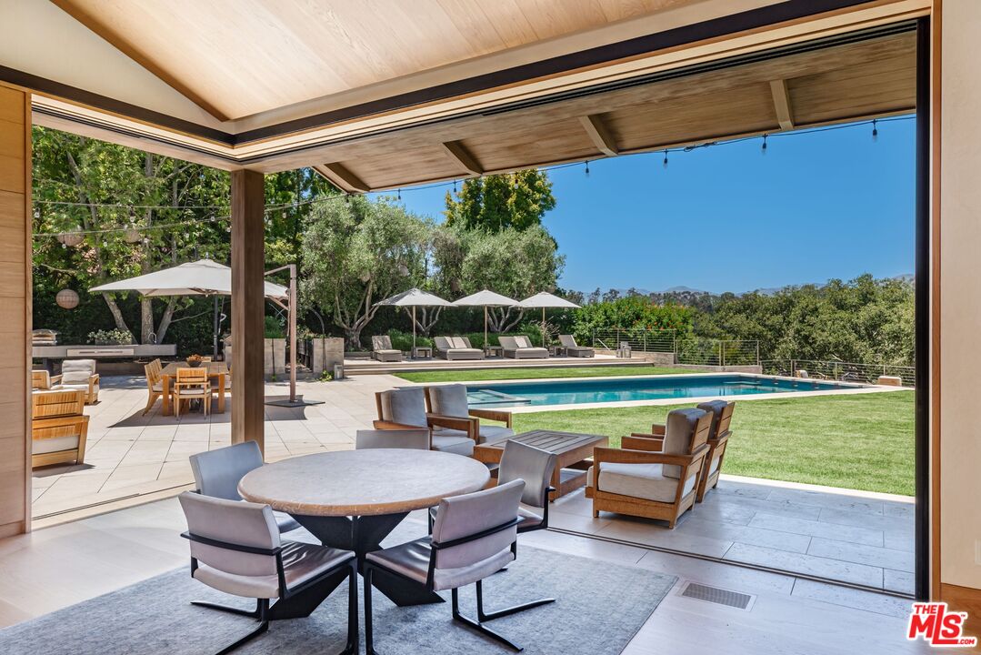 859 Woodacres Road Santa Monica, CA 90402 - Photo 15 of 54 a view of a patio with a table chairs and a swimming pool