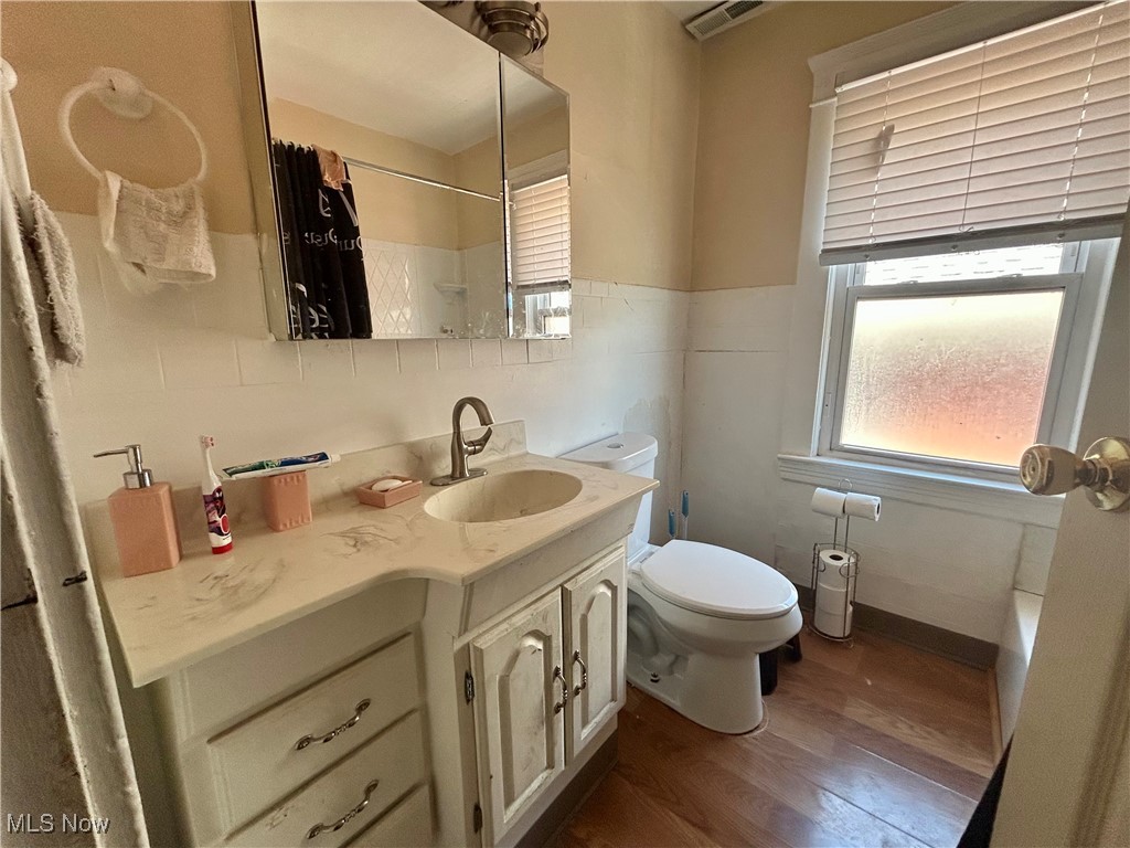 10202 Kinsman Road Cleveland, OH 44104 - Photo 8 of 15 Bathroom with dark wood-style floors, vanity, curtained shower, and a bath