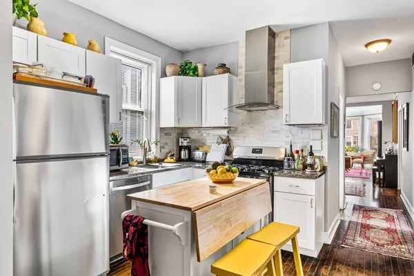 a kitchen with a refrigerator a stove a sink dishwasher and white cabinets with wooden floor
