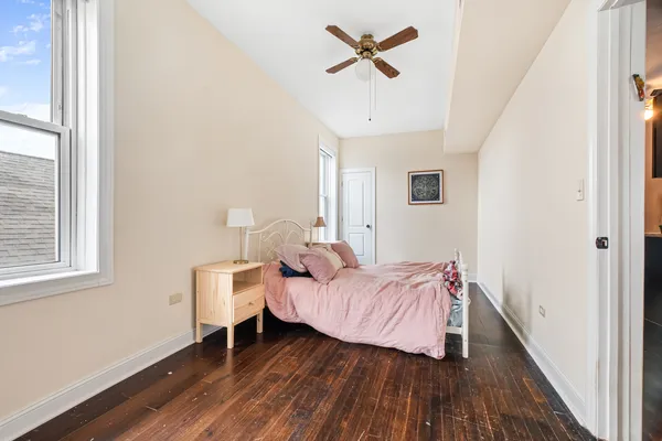 a bedroom with a bed and wooden floor