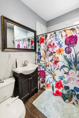 a bathroom with a sink mirror vanity and toilet