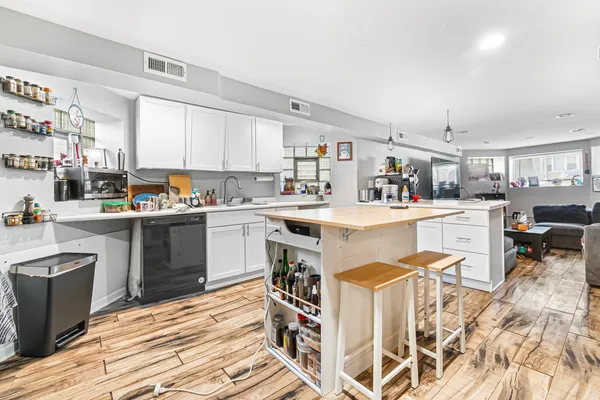 a kitchen with a sink a counter top space stainless steel appliances and cabinets