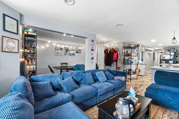 a living room with furniture kitchen and a ceiling fan