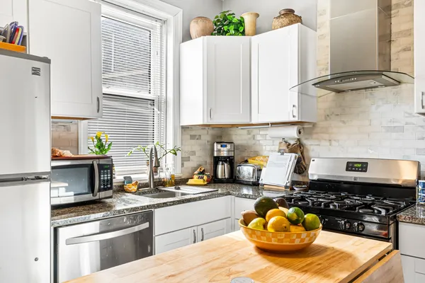 a kitchen with a sink a stove and cabinets