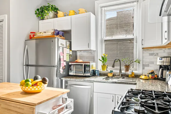 a kitchen with a refrigerator and a stove top oven