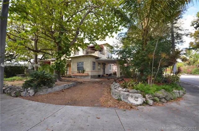 a view of a house with a yard and large tree
