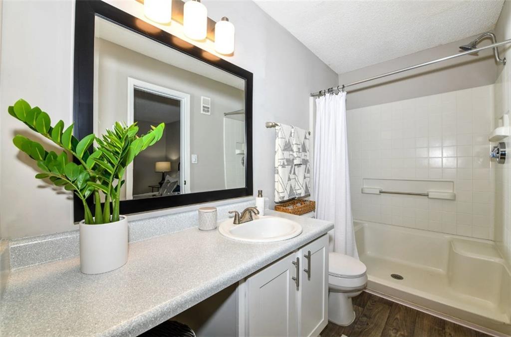 670 Thornton Road, Unit 506 Lithia Springs, GA 30122 - Photo 9 of 26 a bathroom with a granite countertop sink a toilet and a mirror