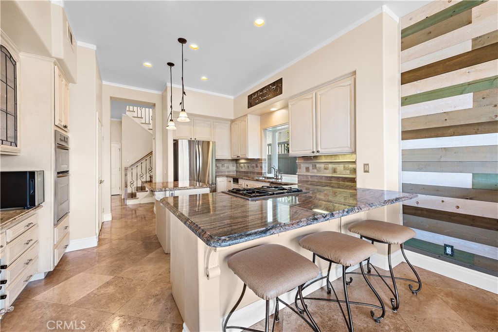 33852 Bridgehampton Drive Dana Point, CA 92629 - Photo 14 of 51 a kitchen with stainless steel appliances granite countertop a stove top oven a sink a dining table and chairs with wooden floor