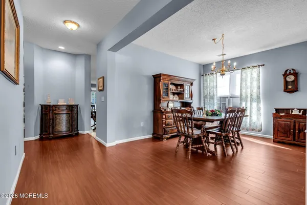 a kitchen with stainless steel appliances kitchen island granite countertop a table chairs and a refrigerator