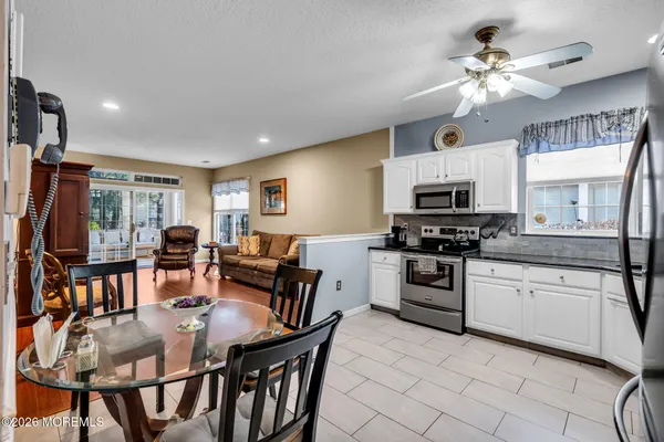 a kitchen with stainless steel appliances a refrigerator a stove a dining table and chairs