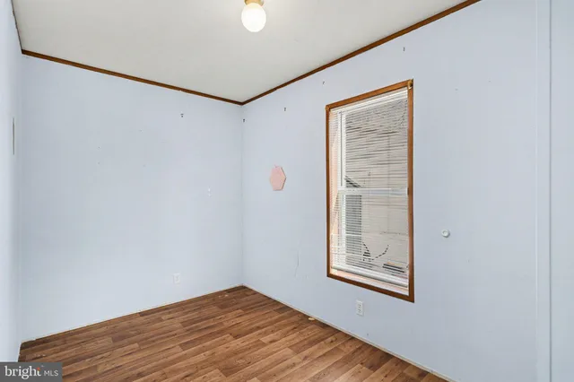 a view of a small space with wooden floor and a window
