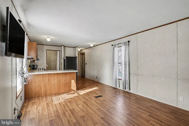 a view of a kitchen with wooden floor and a refrigerator