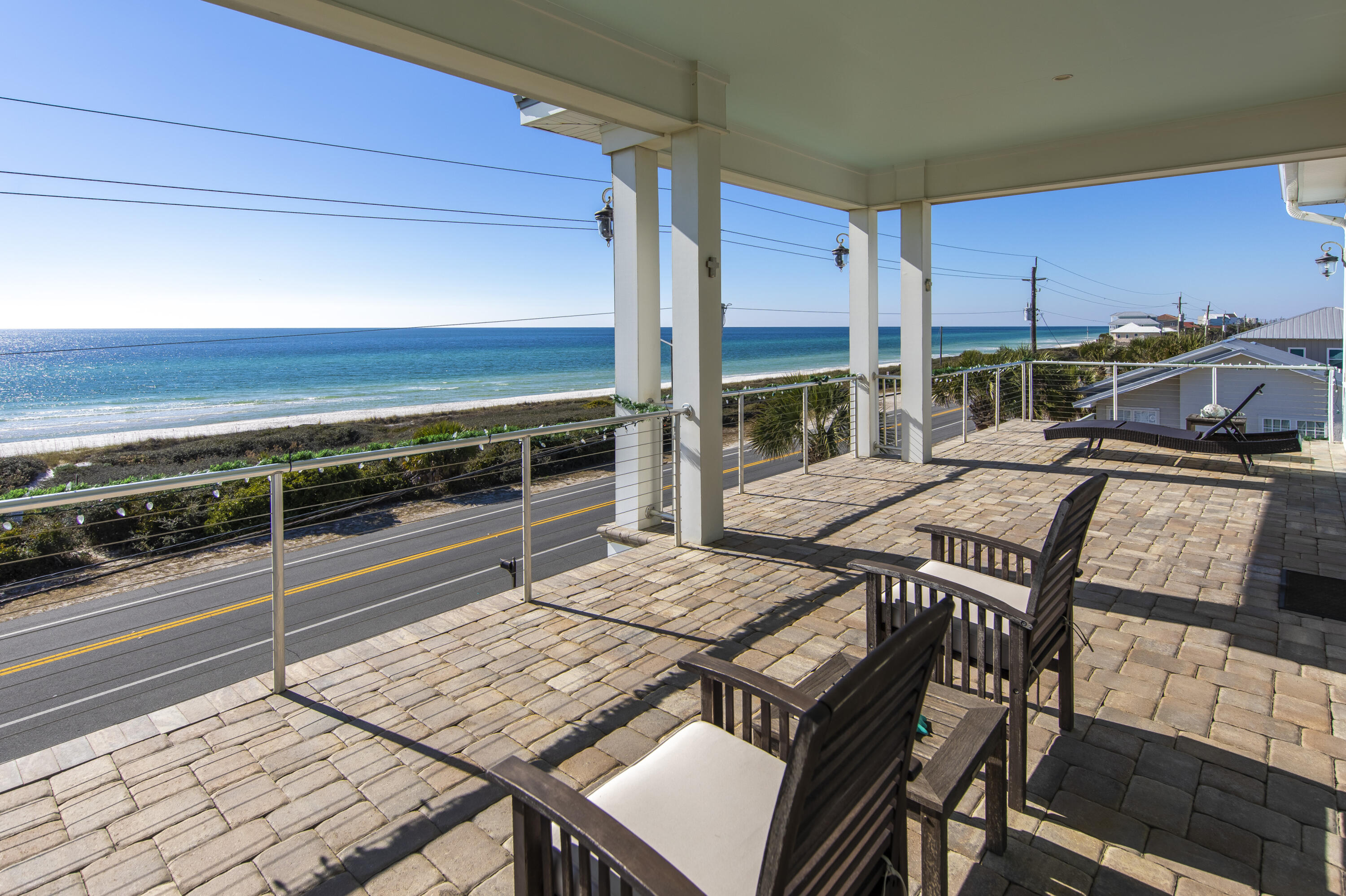 21222 Front Beach Road Panama City Beach, FL 32413 - Photo 50 of 60 a view of a patio with table and chairs and wooden floor