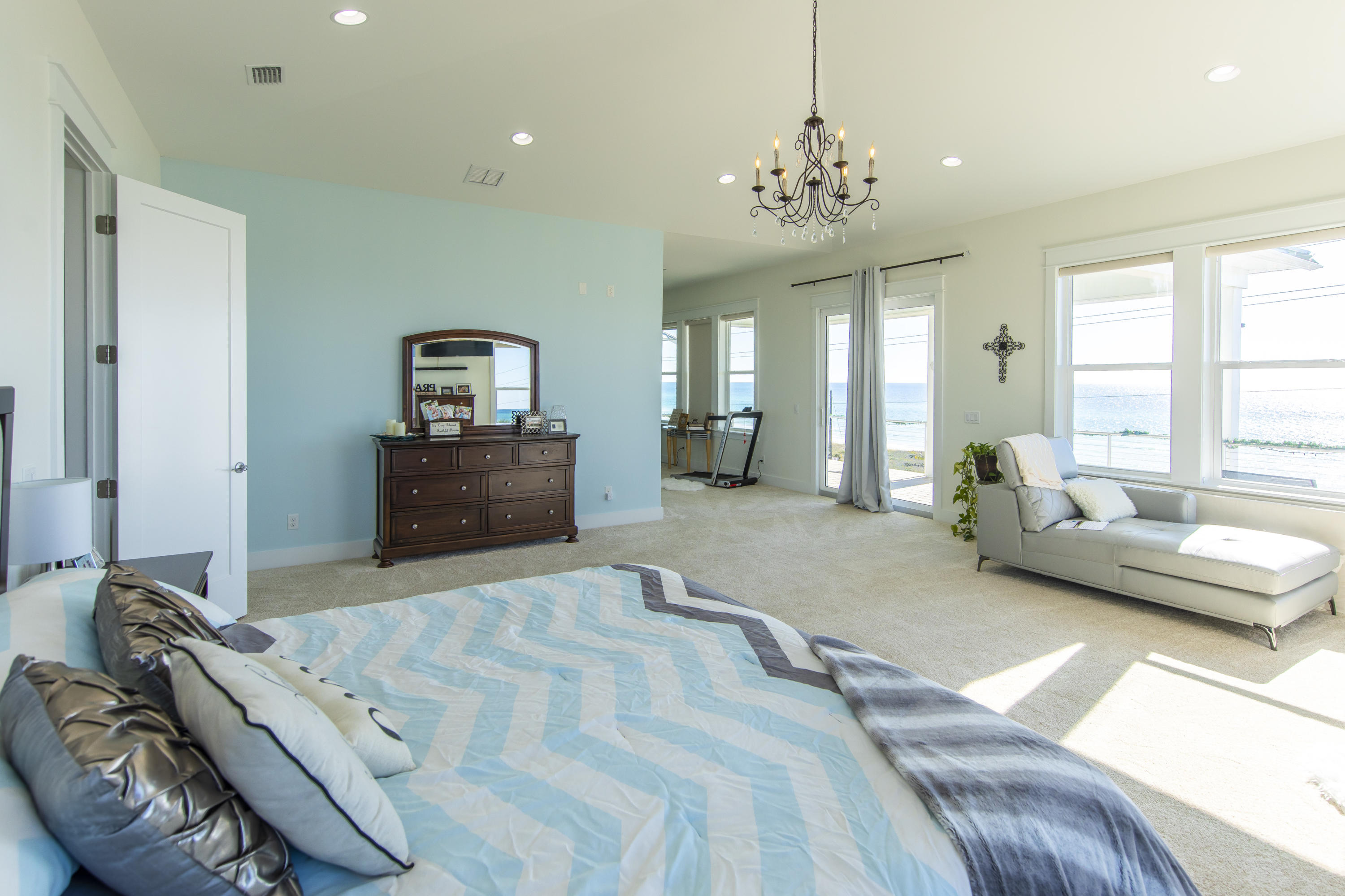 21222 Front Beach Road Panama City Beach, FL 32413 - Photo 53 of 60 a spacious bedroom with a bed and a chandelier
