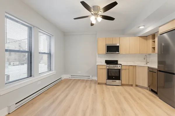 a kitchen with a refrigerator and a stove top oven