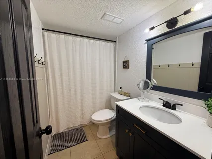 a bathroom with a double vanity sink toilet and a mirror