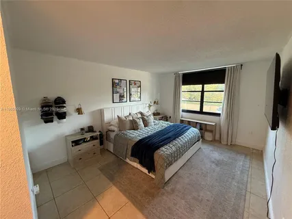 a spacious bedroom with a bed and flat screen tv