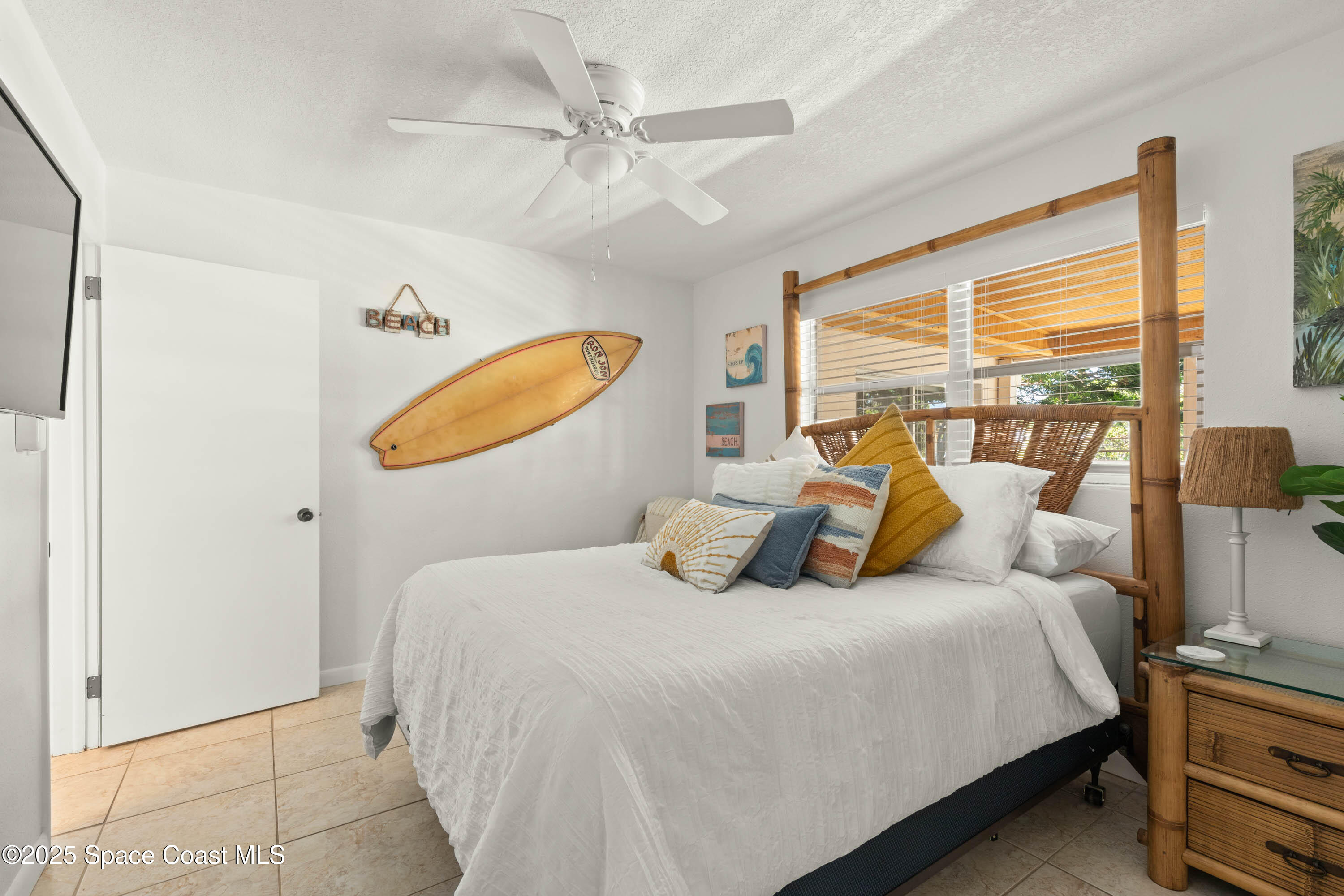 124 Aucila Road Cocoa Beach, FL 32931 - Photo 16 of 58 a bedroom with a bed a lamp and a large window