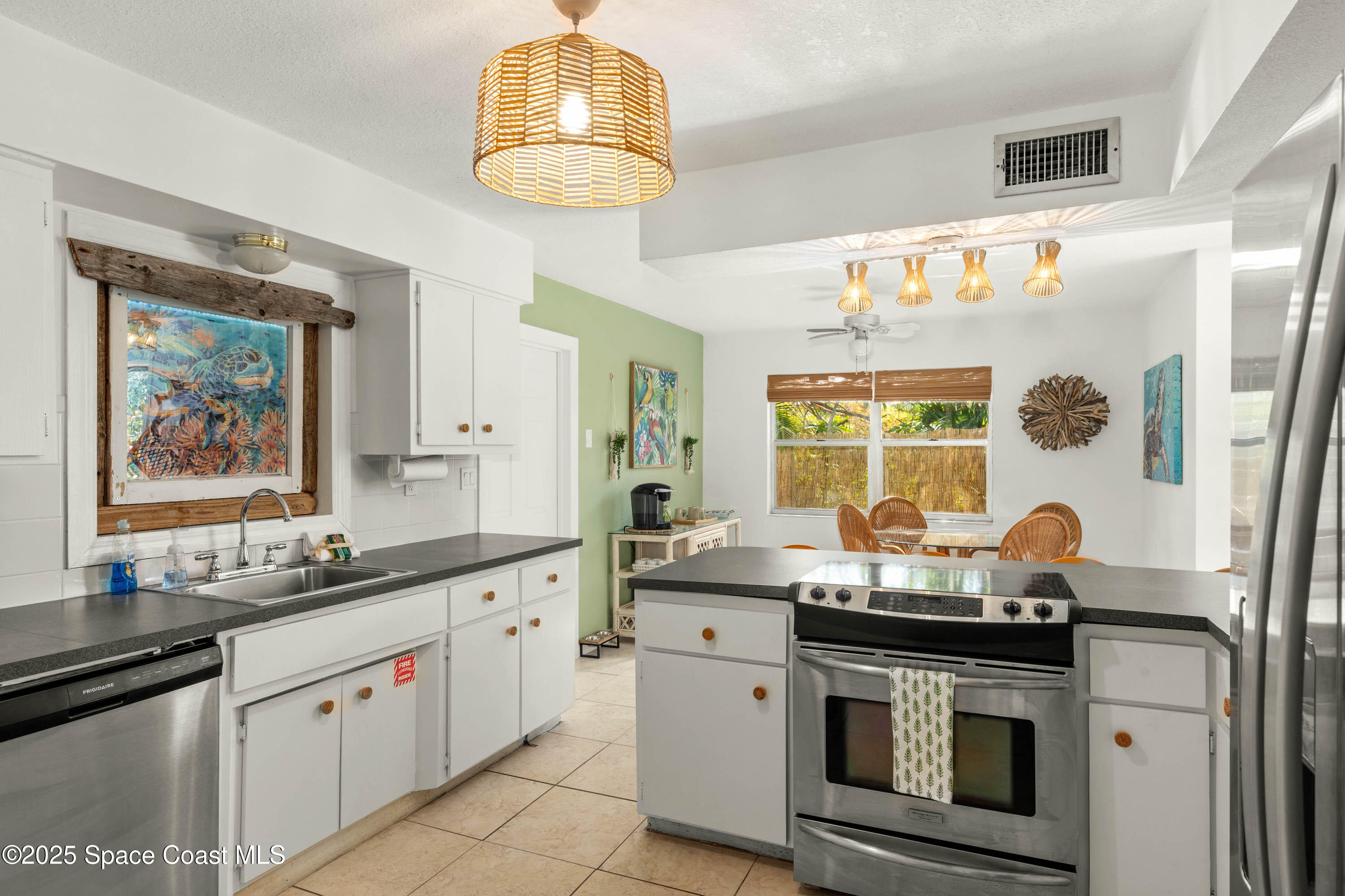 124 Aucila Road Cocoa Beach, FL 32931 - Photo 21 of 58 a kitchen with stainless steel appliances a stove a sink and a refrigerator