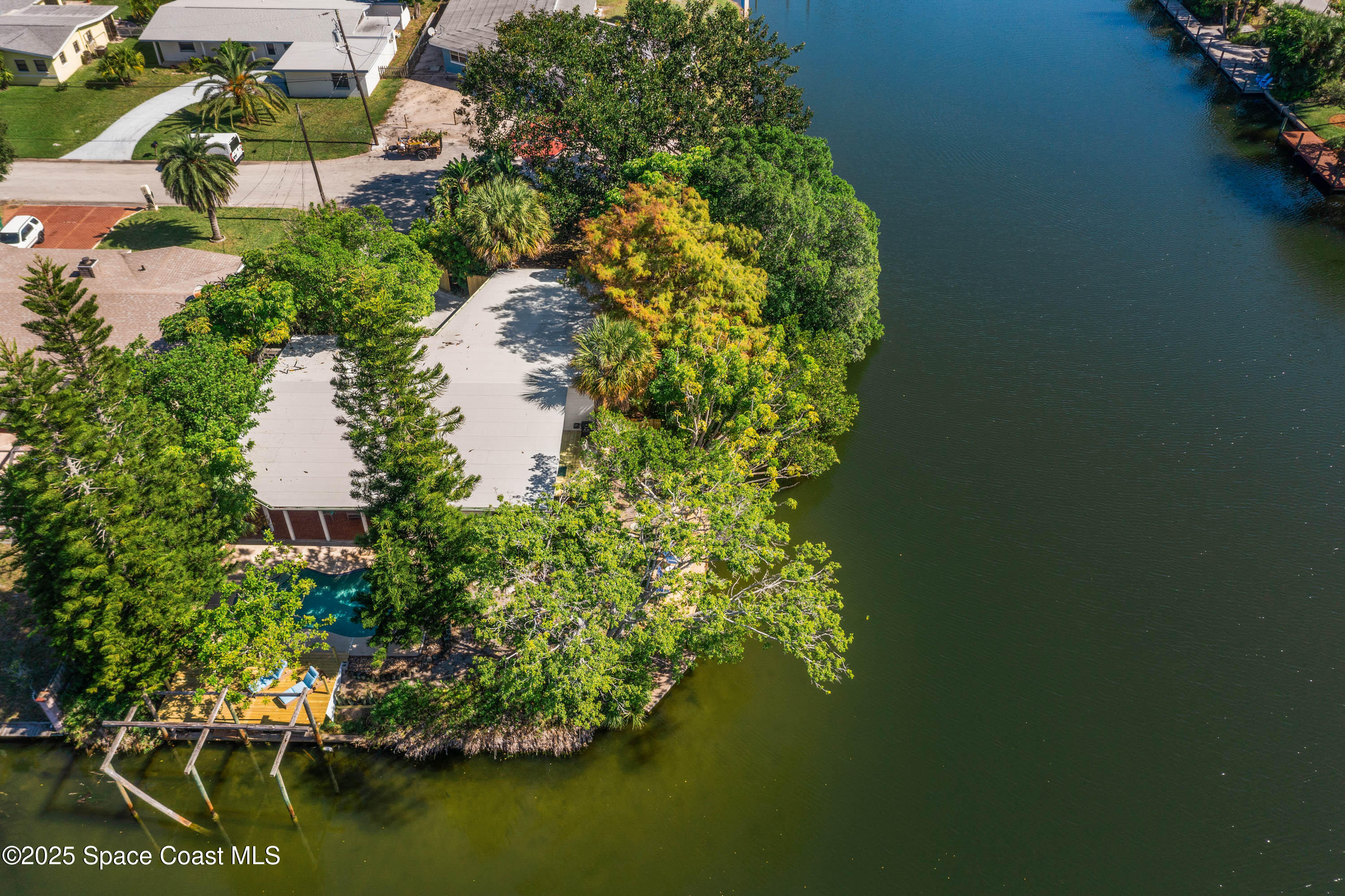 124 Aucila Road Cocoa Beach, FL 32931 - Photo 31 of 58 an aerial view of a house with a yard lake and trees all around