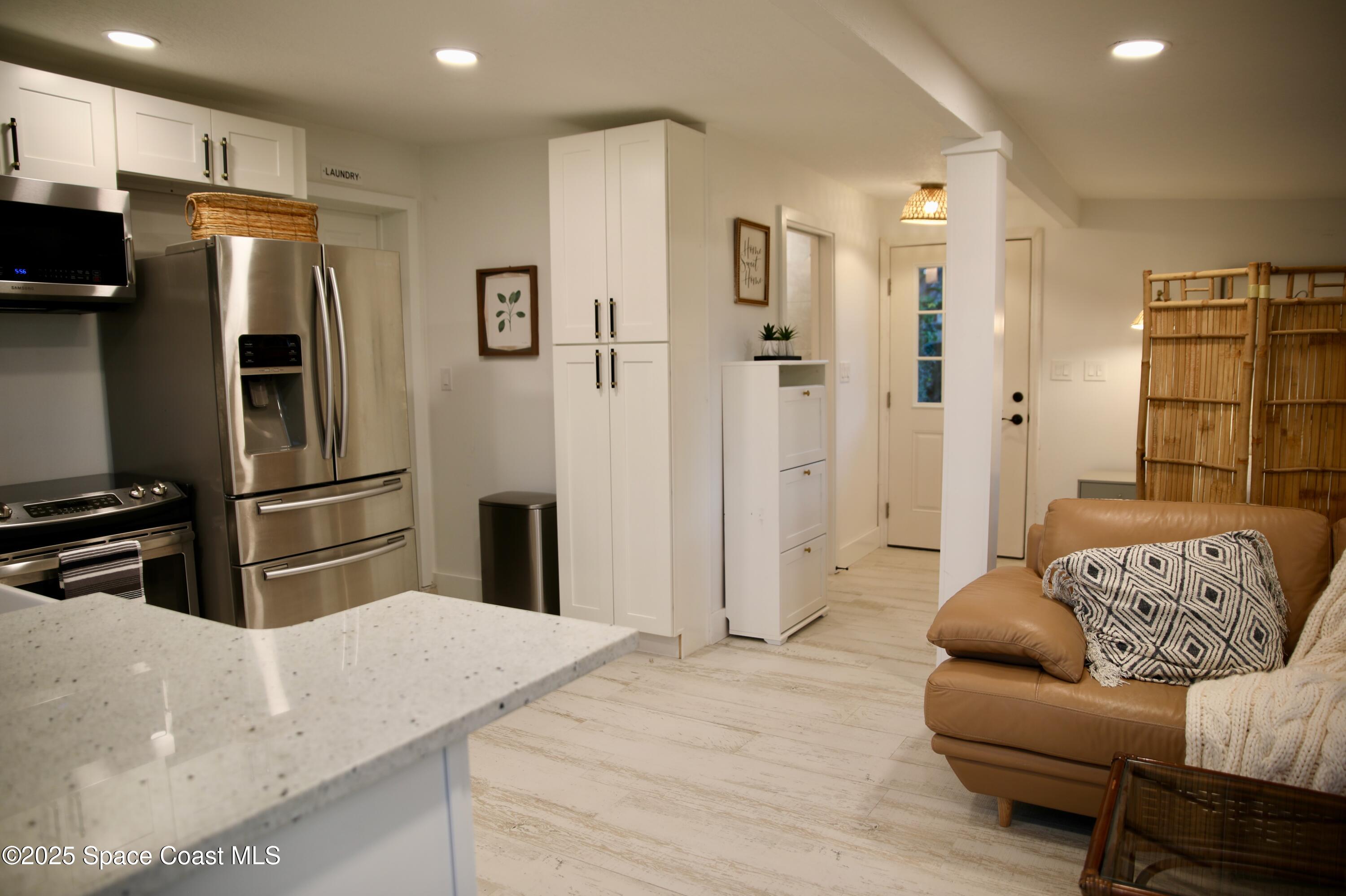 124 Aucila Road Cocoa Beach, FL 32931 - Photo 51 of 58 a kitchen with stainless steel appliances kitchen island granite countertop a refrigerator and a sink