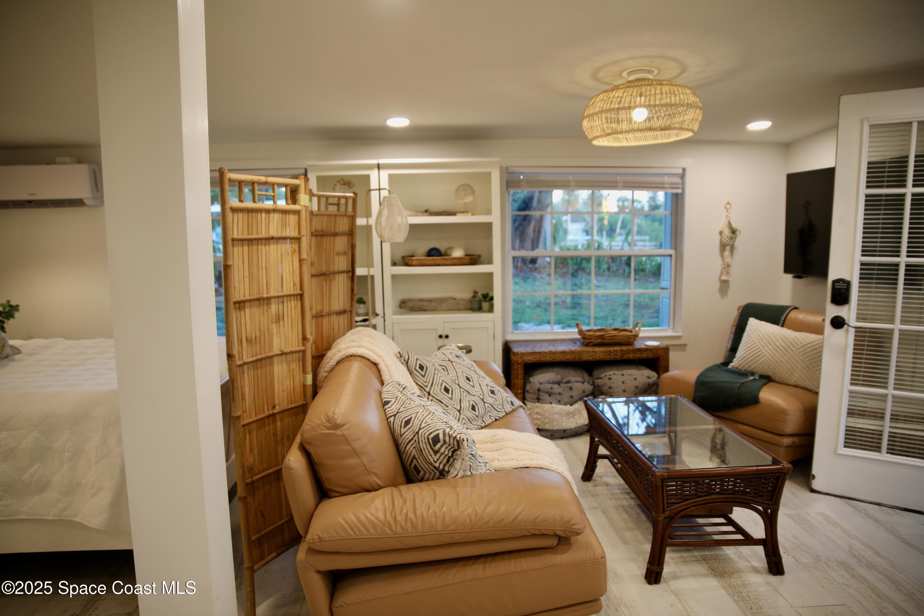 124 Aucila Road Cocoa Beach, FL 32931 - Photo 54 of 58 a living room with furniture and a floor to ceiling window