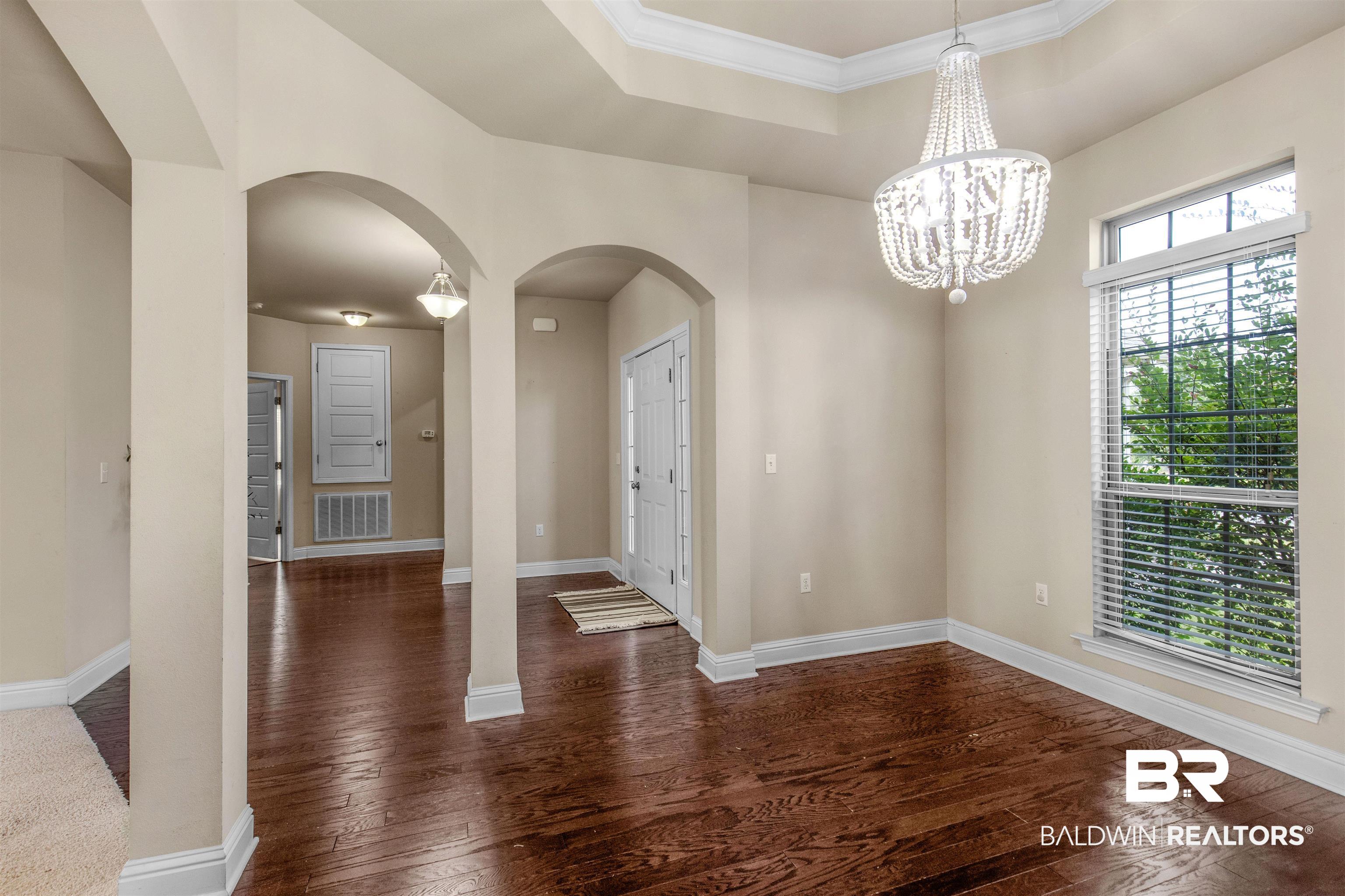122 Open Field Drive Fairhope, AL 36532 - Photo 2 of 27 Foyer featuring dark wood-type flooring, a chandelier, and a raised ceiling