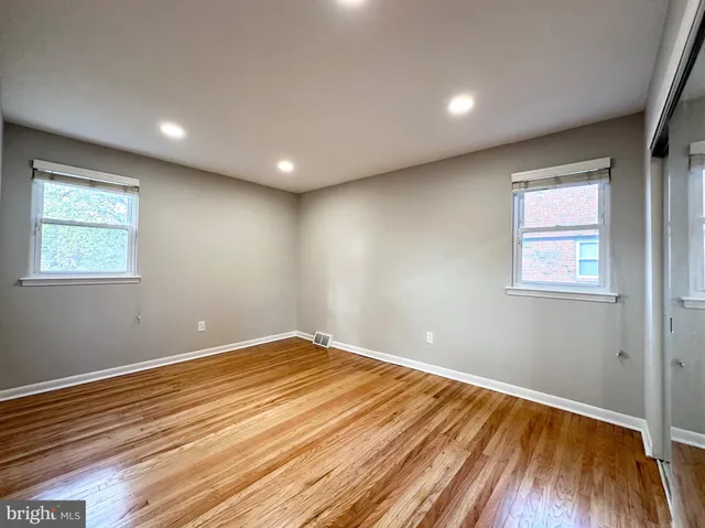 a view of empty room with wooden floor