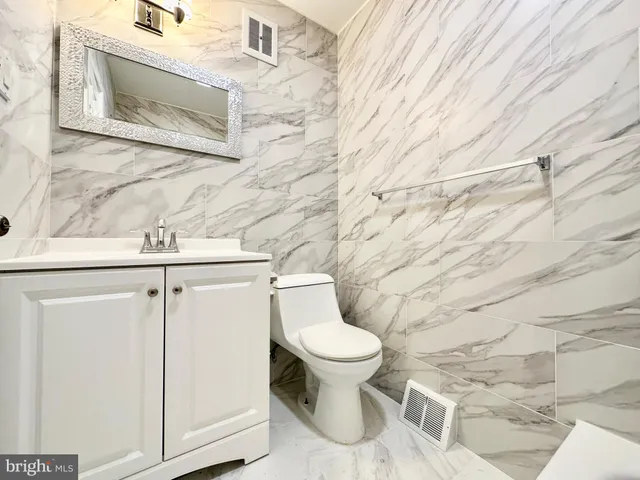 a white toilet sitting next to a shower