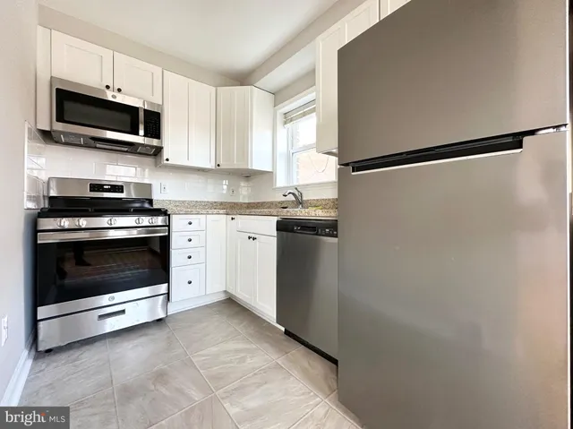 a kitchen with stainless steel appliances a refrigerator sink and microwave