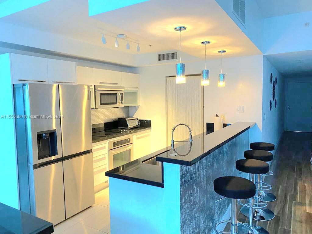 Miami Central Business District Miami, FL 33132 - Photo 6 of 17 a kitchen with stainless steel appliances granite countertop a refrigerator and a stove top oven