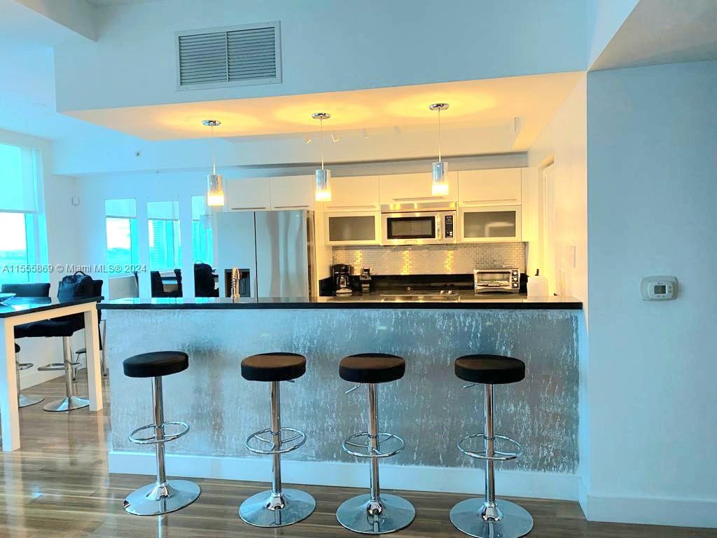 Miami Central Business District Miami, FL 33132 - Photo 7 of 17 a kitchen with stainless steel appliances granite countertop a sink a stove and white cabinets